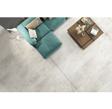 Salon lumineux avec canapé, table et carrelage de sol imitation marbre