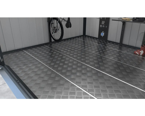 Plancher métallique structuré dans un espace de stockage avec vélo, établi et panneau d''outils