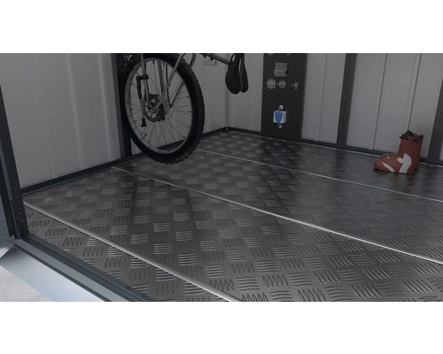 Vue dans une cabane à outils avec un vélo, des outils et une plaque de sol antidérapante.