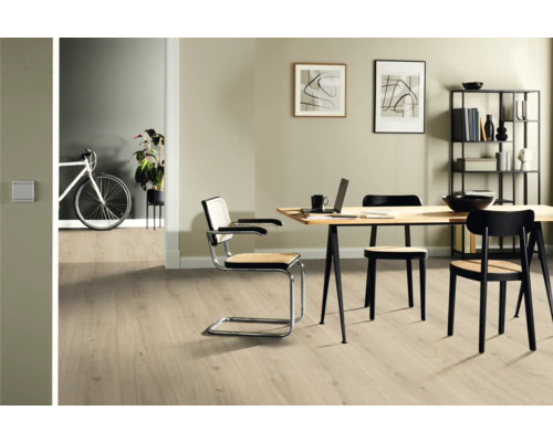 Séjour lumineux avec parquet, table à manger et chaises.