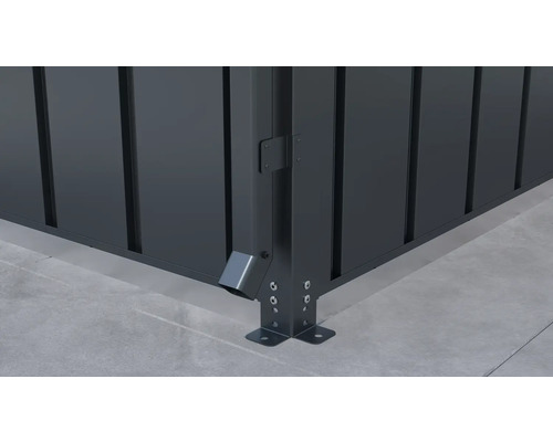 Vue détaillée d''un coin de clôture métallique avec écoulement des eaux de pluie et fixation au sol