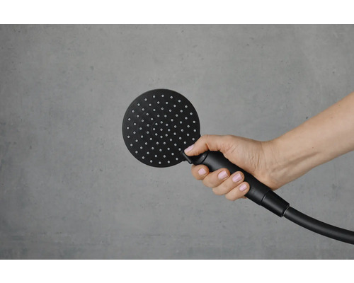 Eine Hand hält einen runden Duschkopf mit Schlauch