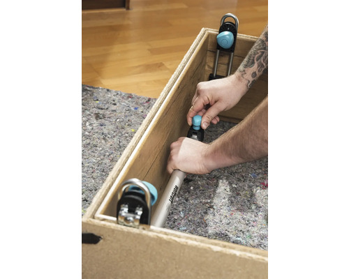 Un homme fixe un équerre de montage Wolfcraft dans une caisse en bois