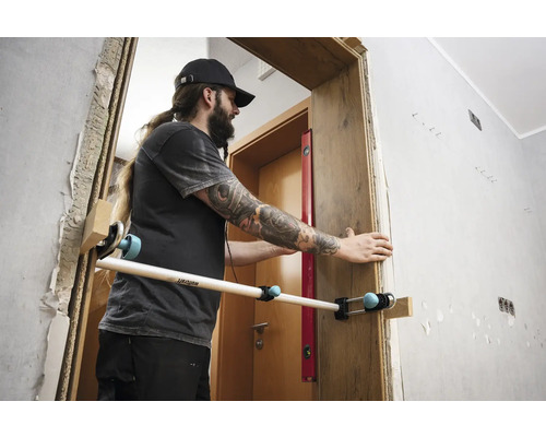 Un homme monte un cadre de porte à l''aide d''un outil de montage