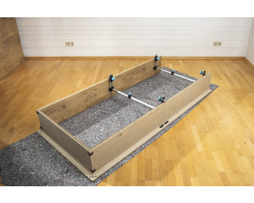 Assemblage d''un cadre en bois avec des tendeurs sur un tapis de protection