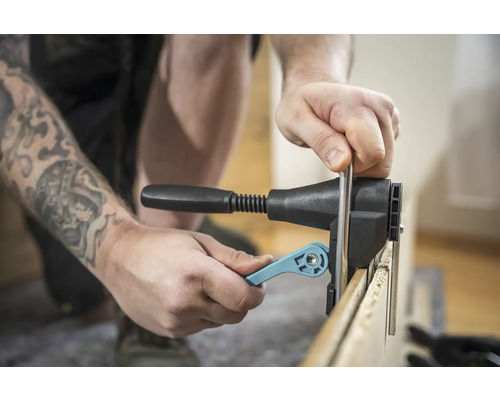 Une personne utilise un gabarit de perçage pour les assemblages en bois.