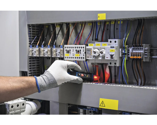 Elektriker prüft eine Schalttafel mit einem Spannungsprüfer