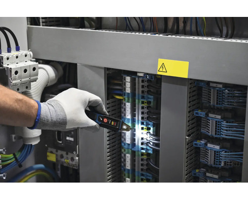 Elektriker prüft mit Spannungsprüfer eine Schalttafel
