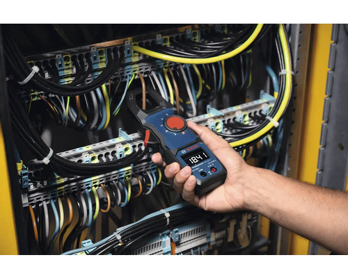 Ein Elektriker verwendet ein Bosch-Strommesszange an einer elektrischen Anlage zur Strommessung.