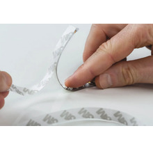 Eine LED Leiste wird mit Klebeband befestigt.