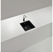 Schwarze Küchenspüle mit Armatur auf einer weißen Arbeitsplatte