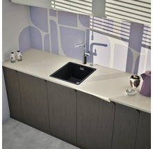 Küchenszene mit Spüle, Armatur und Küchenutensilien auf einer Arbeitsplatte