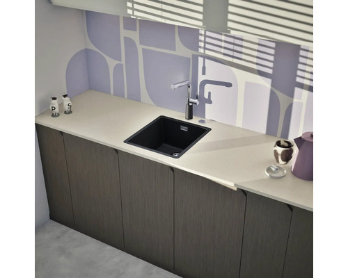 Küchenszene mit Spüle, Armatur und Küchenutensilien auf einer Arbeitsplatte