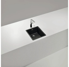 Schwarze Küchenspüle mit Armatur auf einer weißen Arbeitsplatte