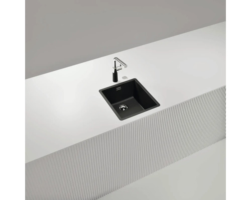 Schwarze Küchenspüle mit Armatur auf einer weißen Arbeitsplatte