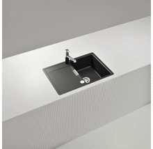 Schwarze Küchenspüle mit Abtropffläche und Armatur auf einer Arbeitsplatte