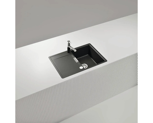 Schwarze Küchenspüle mit Abtropffläche und Armatur auf einer Arbeitsplatte