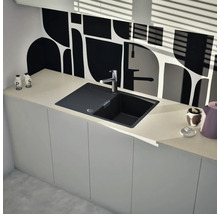 Spüle aus Granit mit Wasserhahn in einer modernen Küche mit weißen Schränken und gemusterter Rückwand