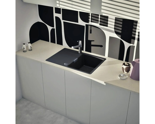 Spüle aus Granit mit Wasserhahn in einer modernen Küche mit weißen Schränken und gemusterter Rückwand