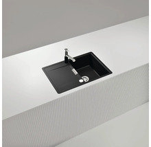 Schwarze Küchenspüle mit Abtropffläche und Armatur auf einer Küchentheke