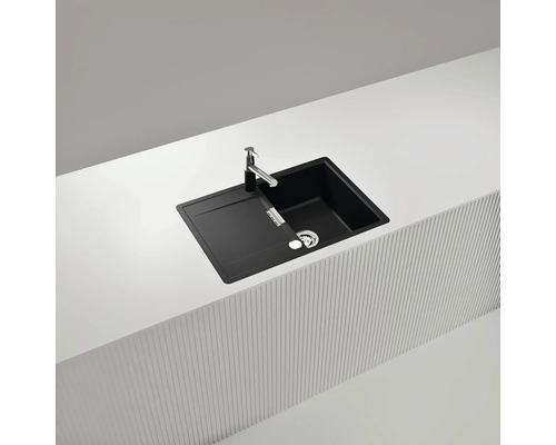 Schwarze Küchenspüle mit Abtropffläche und Armatur auf einer Küchentheke