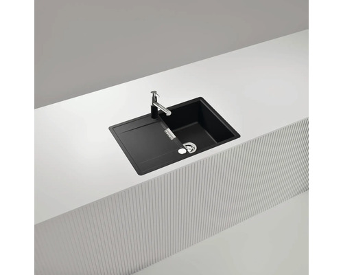 Schwarze Küchenspüle mit Abtropffläche und Armatur auf einer Arbeitsplatte.