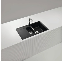 Schwarzes Spülbecken mit Abtropffläche und Wasserhahn auf einer Arbeitsplatte