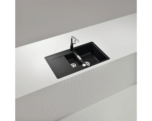 Schwarzes Spülbecken mit Abtropffläche und Wasserhahn auf einer Arbeitsplatte