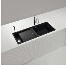 Schwarze Küchenspüle mit Abtropffläche, Armatur und Spülmittelspender auf einer Kücheninsel