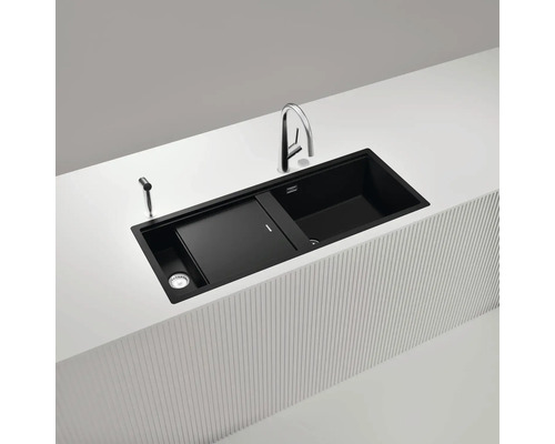 Schwarze Küchenspüle mit Abtropffläche, Armatur und Spülmittelspender auf einer Kücheninsel