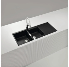 Évier double noir avec égouttoir et robinet dans un îlot de cuisine clair.