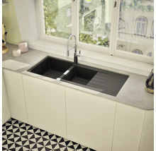 Évier à deux bacs et égouttoir sous une fenêtre dans une cuisine