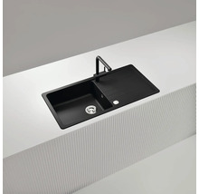 Schwarze Küchenspüle mit Abtropffläche und Armatur auf einer Küchentheke