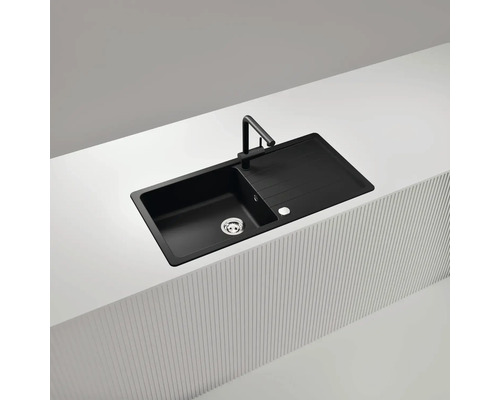 Schwarze Küchenspüle mit Abtropffläche und Armatur auf einer Küchentheke