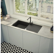 Spüle mit Abtropffläche und Armatur in einer hellen Küche vor einem Fenster