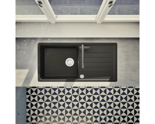 Draufsicht auf eine schwarze Küchenspüle mit Abtropffläche, Armatur und Abfluss