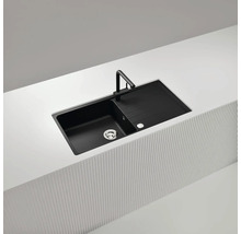 Schwarze Küchenspüle mit Abtropffläche und Armatur auf einer Küchentheke