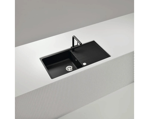 Schwarze Küchenspüle mit Abtropffläche und Armatur auf einer Küchentheke