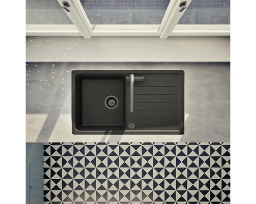 Ansicht von oben auf eine schwarze Küchenspüle mit Abtropffläche und Küchenarmatur