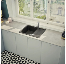 Spüle aus Verbundwerkstoff mit Abtropffläche und Armatur auf einer Küchentheke