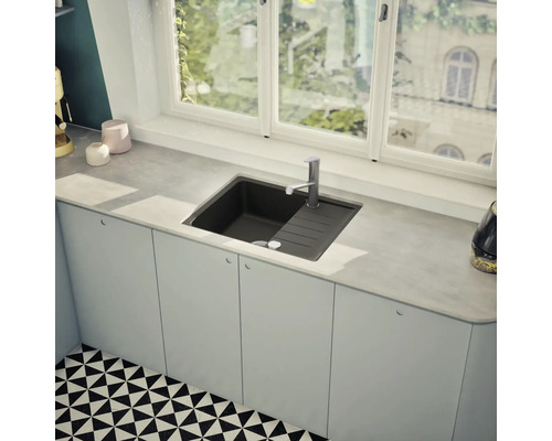 Spüle aus Stein mit Abtropffläche und Einhebelmischer in einer hellen Küche