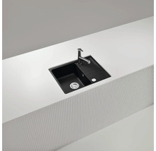 Schwarzes Spülbecken mit Abtropffläche und Armatur auf einer Küchenarbeitsplatte