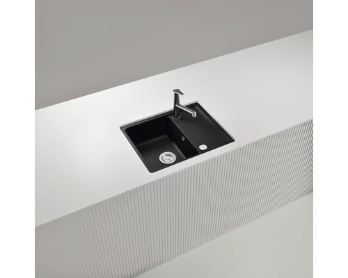 Schwarzes Spülbecken mit Abtropffläche und Armatur auf einer Küchenarbeitsplatte