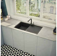 Küchenspüle mit Abtropffläche und Wasserhahn vor einem Fenster