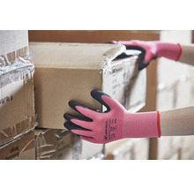Femme portant des gants de travail, transportant un carton