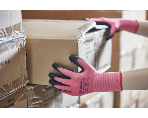 Une personne portant des gants de travail soulève un carton.