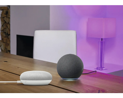 Szene mit einem intelligenten Lautsprecher und einem intelligenten Heimgerät auf einem Holztisch