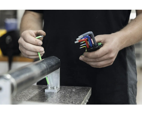 Ein Mann hält einen Satz farbcodierter Innensechskantschlüssel in der Hand.