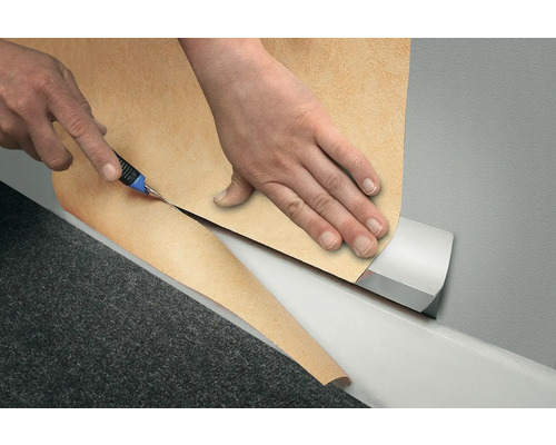Découpe de moquette avec un cutter à moquette et un guide de coupe