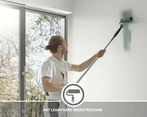 Un homme peint un mur avec un rouleau à peinture et de la peinture à l''argile.